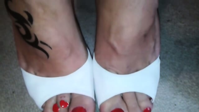 Cougar Showing Off Her Glamorous Red Toe Nails And Toe Rings In Heels