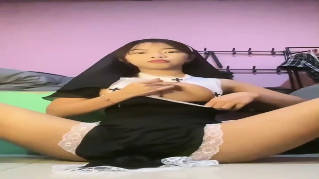 Asian cutie rubbing her cunt in sexy nun costume