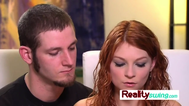Redhead gets fucked at the red room by horny swingers in front of her boyfriend for a TV show.
